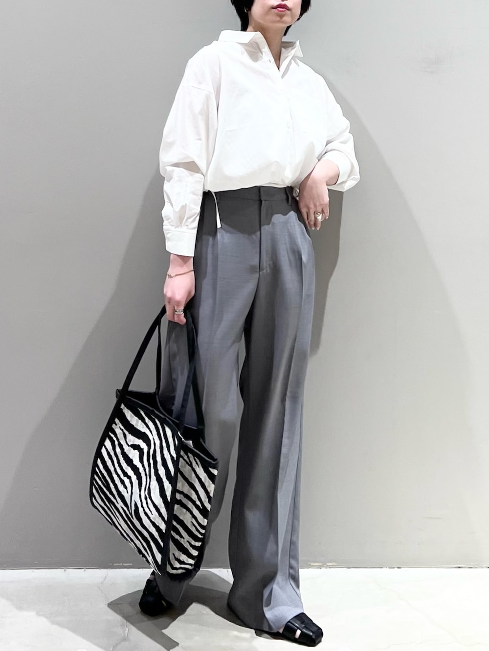 ホワイト系のシャツ/ブラウス、ブラック系のバッグ、グレー系のデニムパンツを着用したレディースの春コーディネートの6枚目の写真