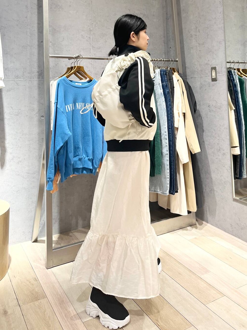 ホワイト系のスカート、ブラック系のブーツ、ブルー系のTシャツ/カットソーを着用したレディースの冬コーディネートの5枚目の写真