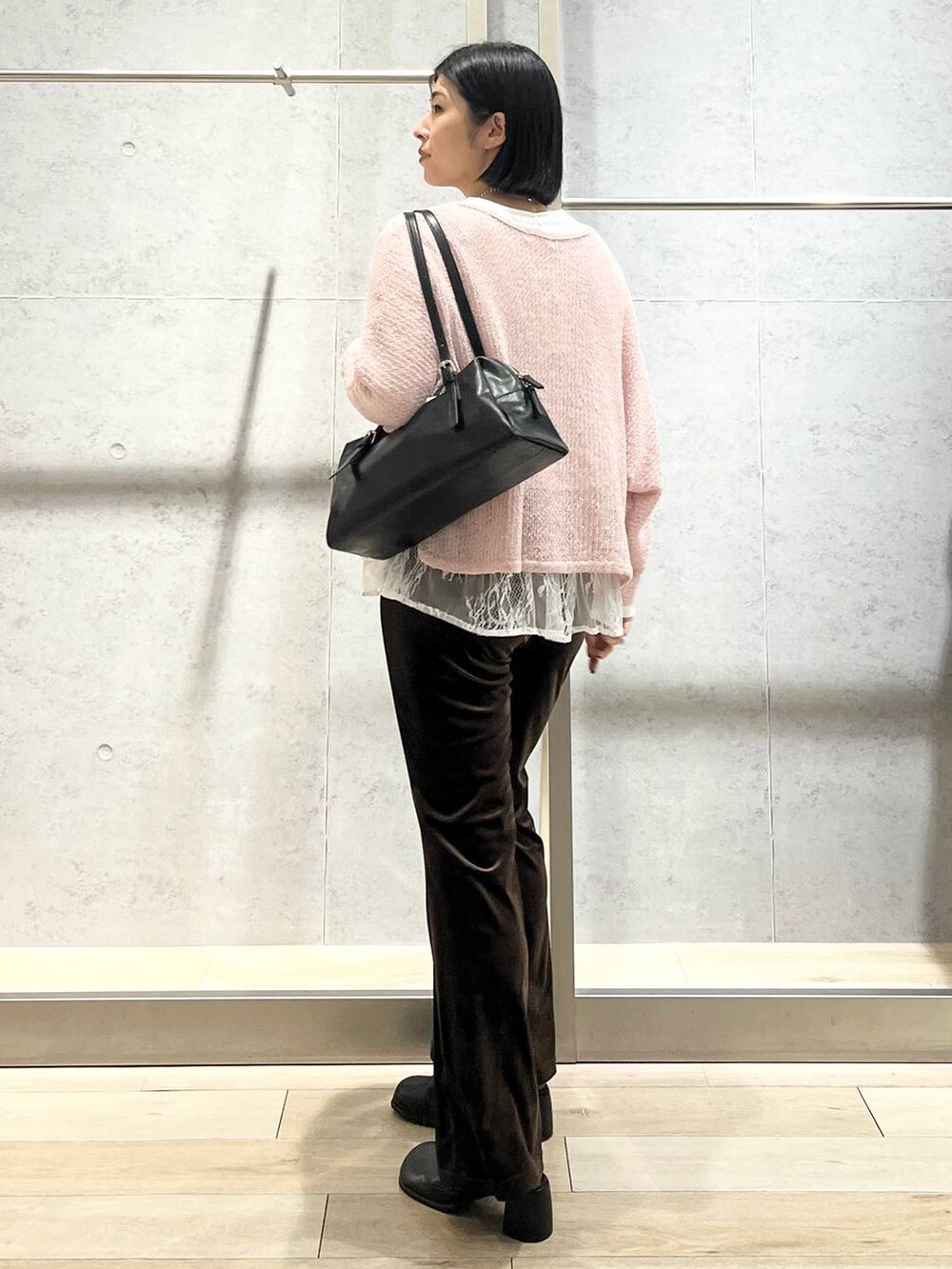 ピンク系のニット/セーター、ブラウン系のその他パンツ、ブラック系のその他シューズを着用したレディースの秋コーディネートの2枚目の写真