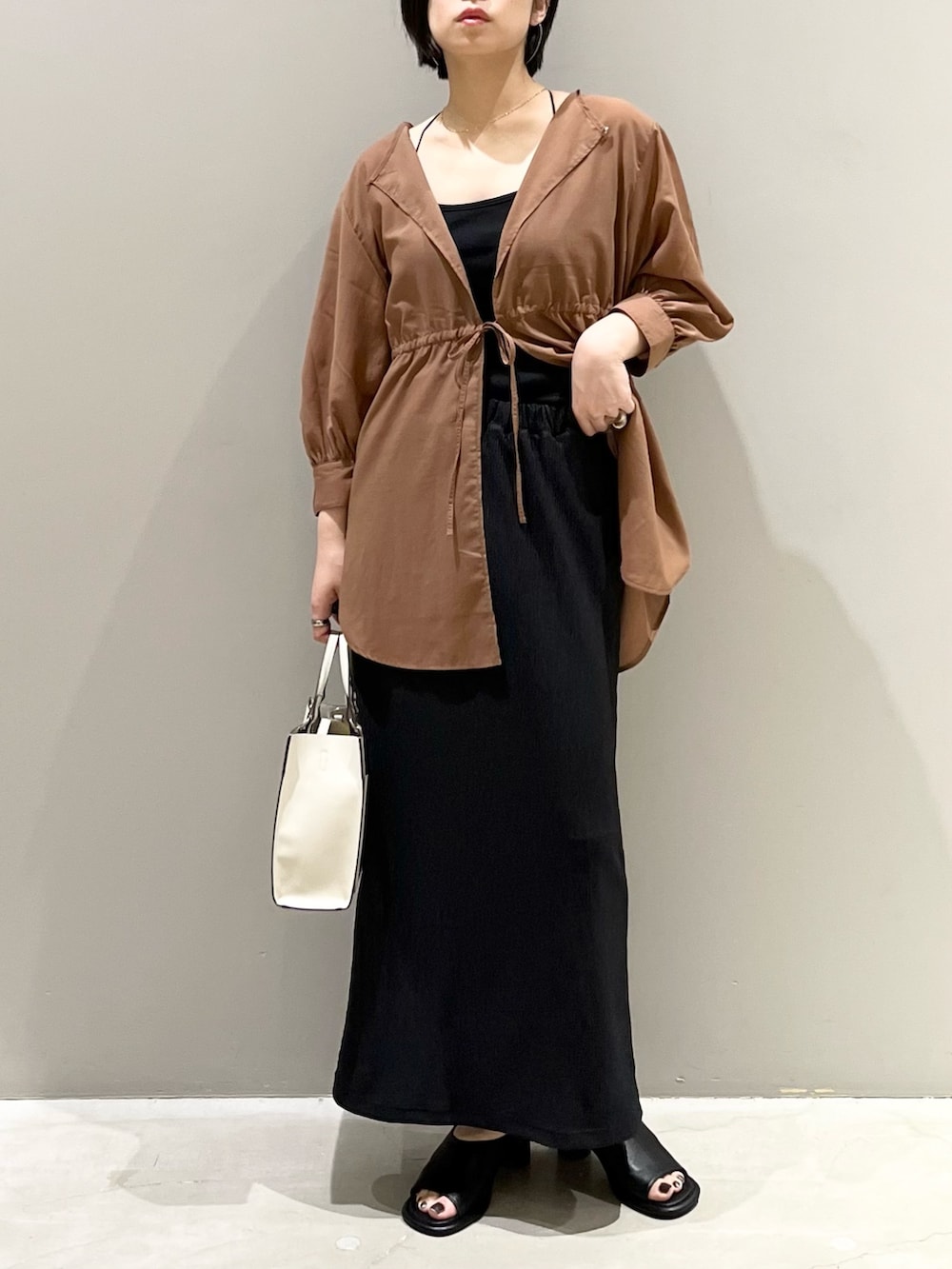 イエロー系のシャツ/ブラウス、ブラック系のスカート、ブラウン系のバッグを着用したレディースの秋コーディネートの8枚目の写真