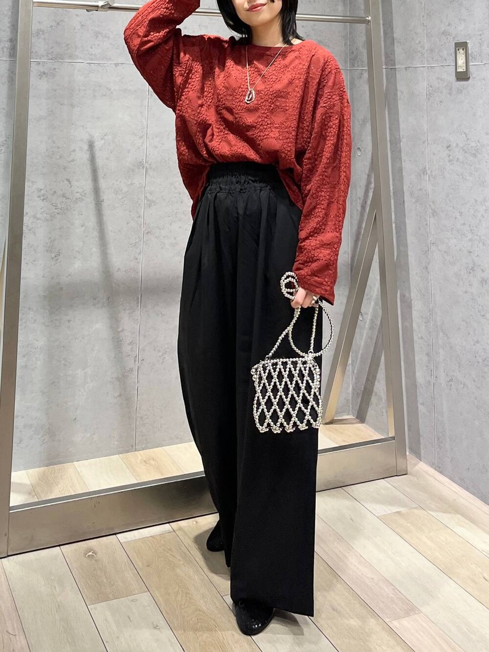 レッド系のTシャツ/カットソー、ブラック系のスラックス、シルバー系のショルダーバッグを着用したレディースの夏コーディネートの2枚目の写真