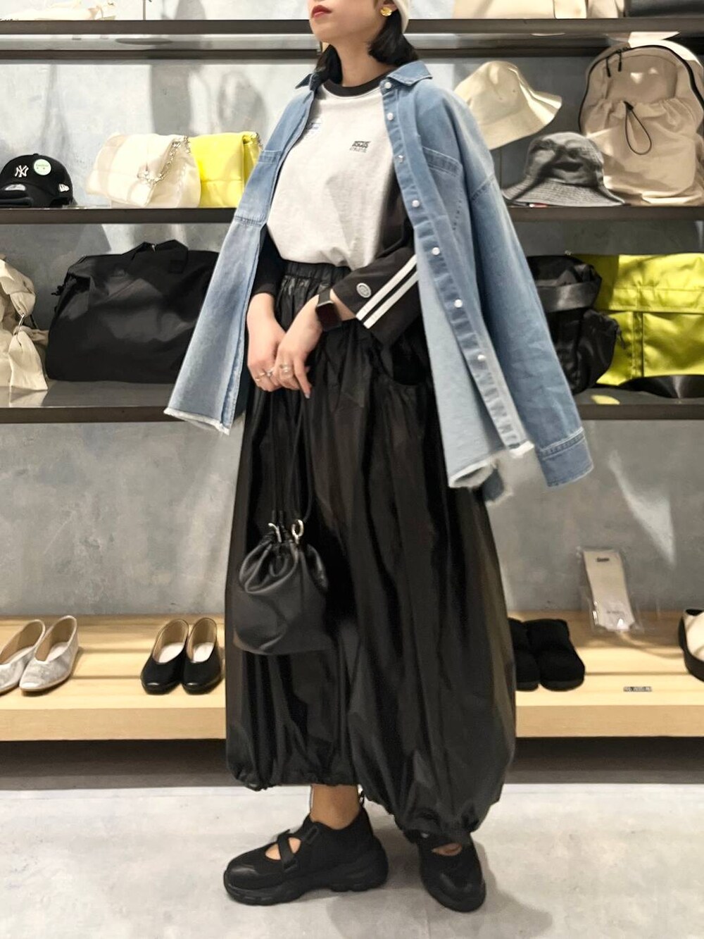 ブラック系のショルダーバッグ、ブラック系のTシャツ/カットソー、ブラック系のスニーカーを着用したレディースの春コーディネートの7枚目の写真