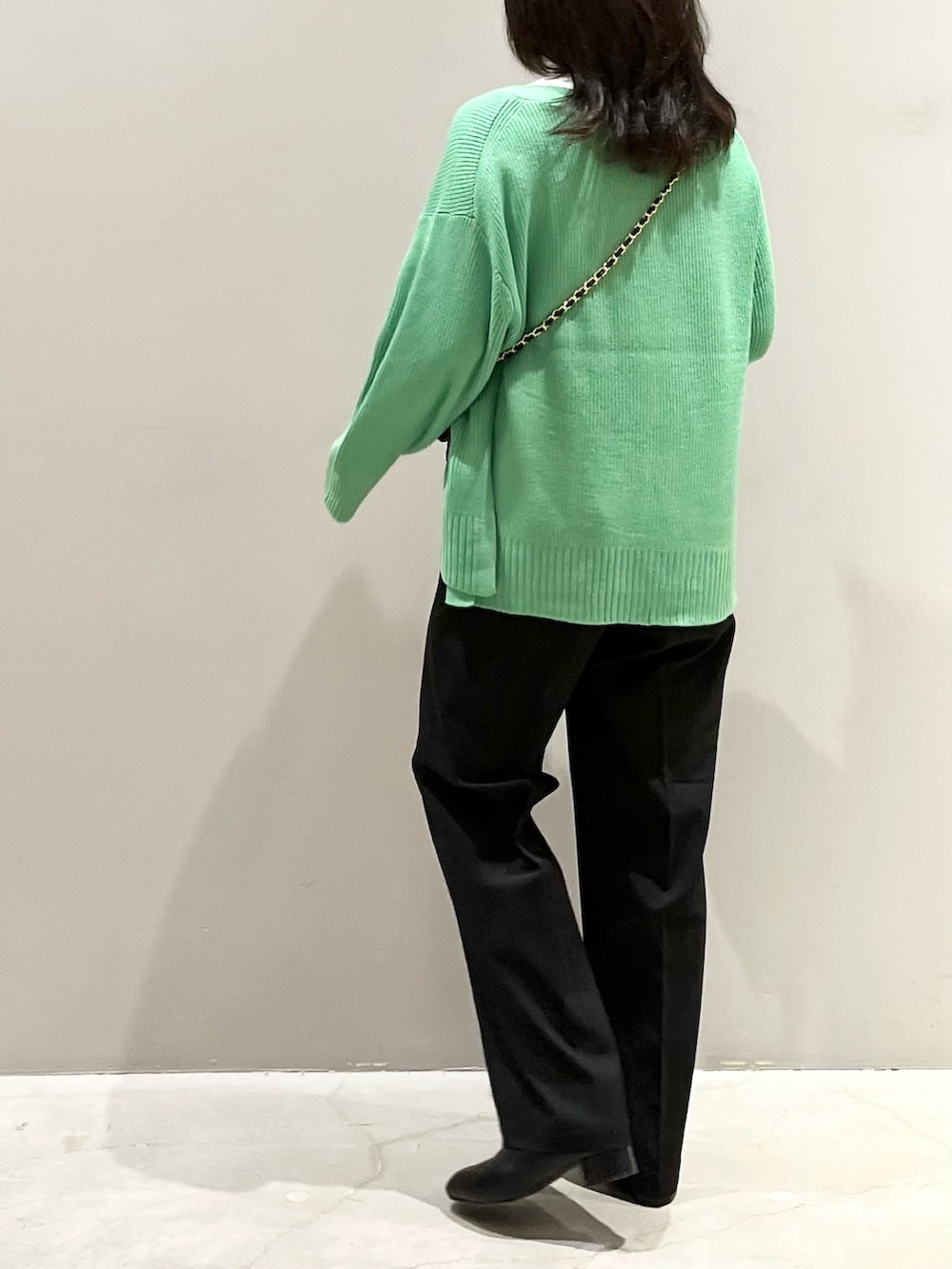 ブラック系のブーツ、ブラック系のスラックス、ブラック系のショルダーバッグを着用したレディースの秋コーディネートの3枚目の写真