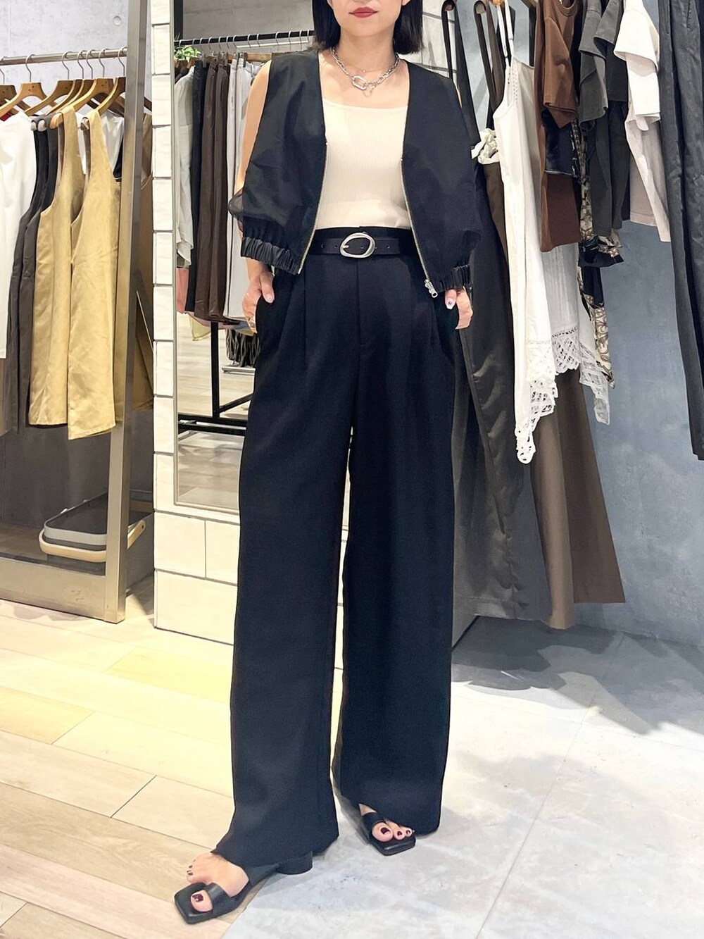 ホワイト系のタンクトップ、ブラック系のその他パンツ、オレンジ系のショルダーバッグを着用したレディースの夏コーディネートの5枚目の写真