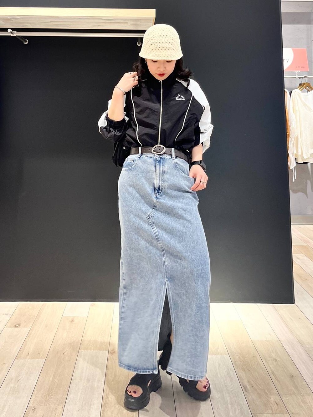 ブルー系のデニムスカート、ブラック系のショルダーバッグ、ブラック系のサンダルを着用したレディースの春コーディネートの5枚目の写真