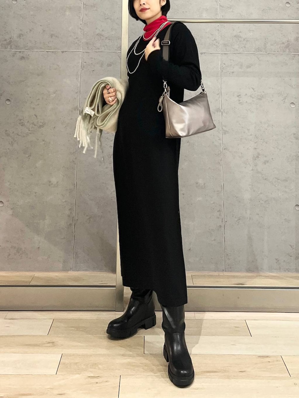 ブラック系のブーツ、その他のショルダーバッグ、ブラック系のワンピースを着用したレディースの冬コーディネートの5枚目の写真