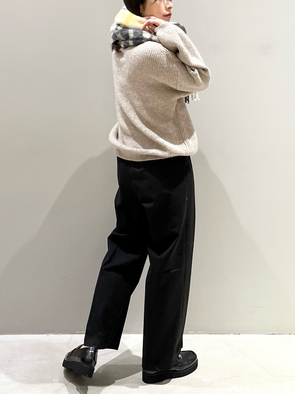 ブラウン系のニット/セーター、ブラック系のローファー、ブラック系のスラックスを着用したレディースの冬コーディネートの3枚目の写真