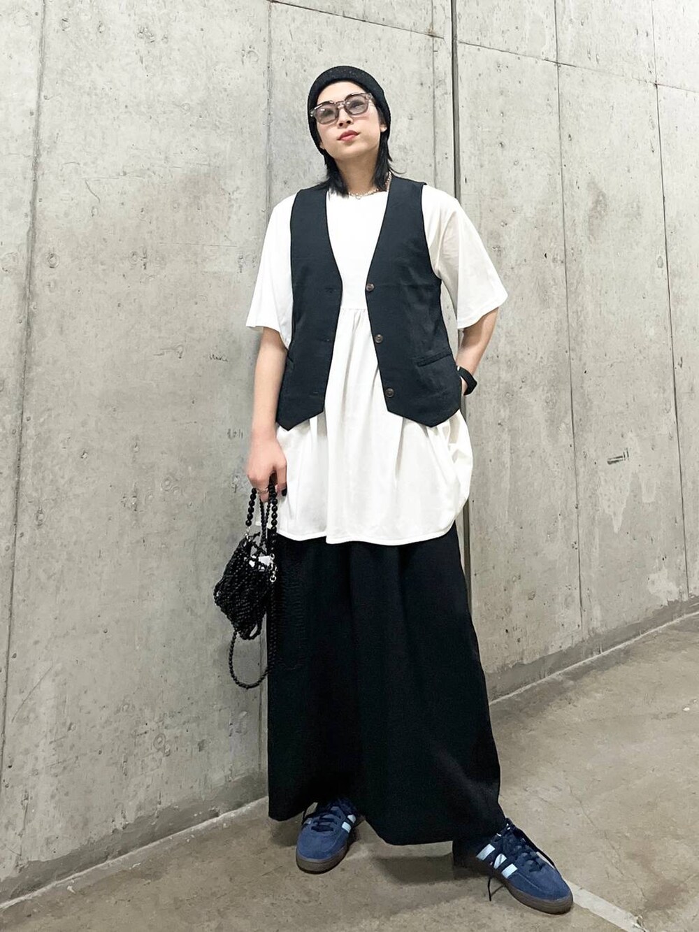 ブラック系のスラックス、ブラック系のショルダーバッグ、グレー系のベストを着用したレディースの夏コーディネートの8枚目の写真