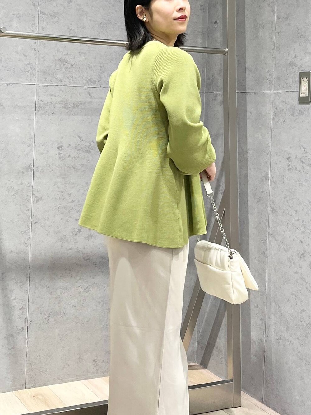 ホワイト系のショルダーバッグ、グリーン系のニット/セーター、ホワイト系のスカートを着用したレディースの春コーディネートの7枚目の写真