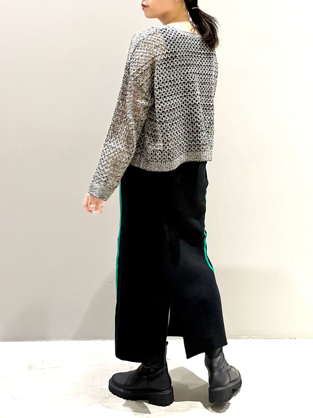 ブラック系のニット/セーター、ホワイト系のショルダーバッグ、ブラック系のブーツを着用したレディースの秋コーディネートの3枚目の写真