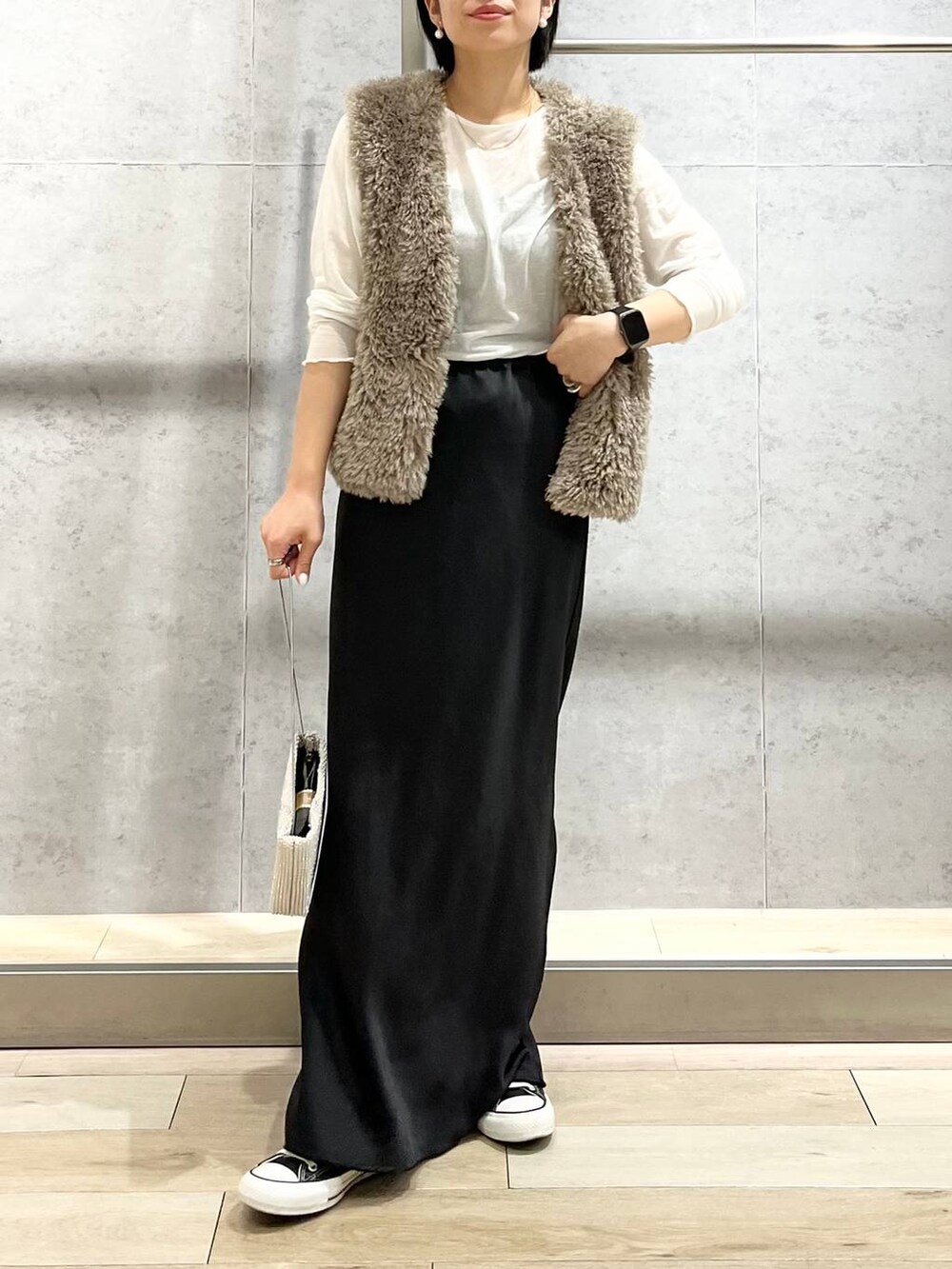 ブラック系のキャミソール、ベージュ系のベスト、ホワイト系のTシャツ/カットソーを着用したレディースの秋コーディネートの2枚目の写真