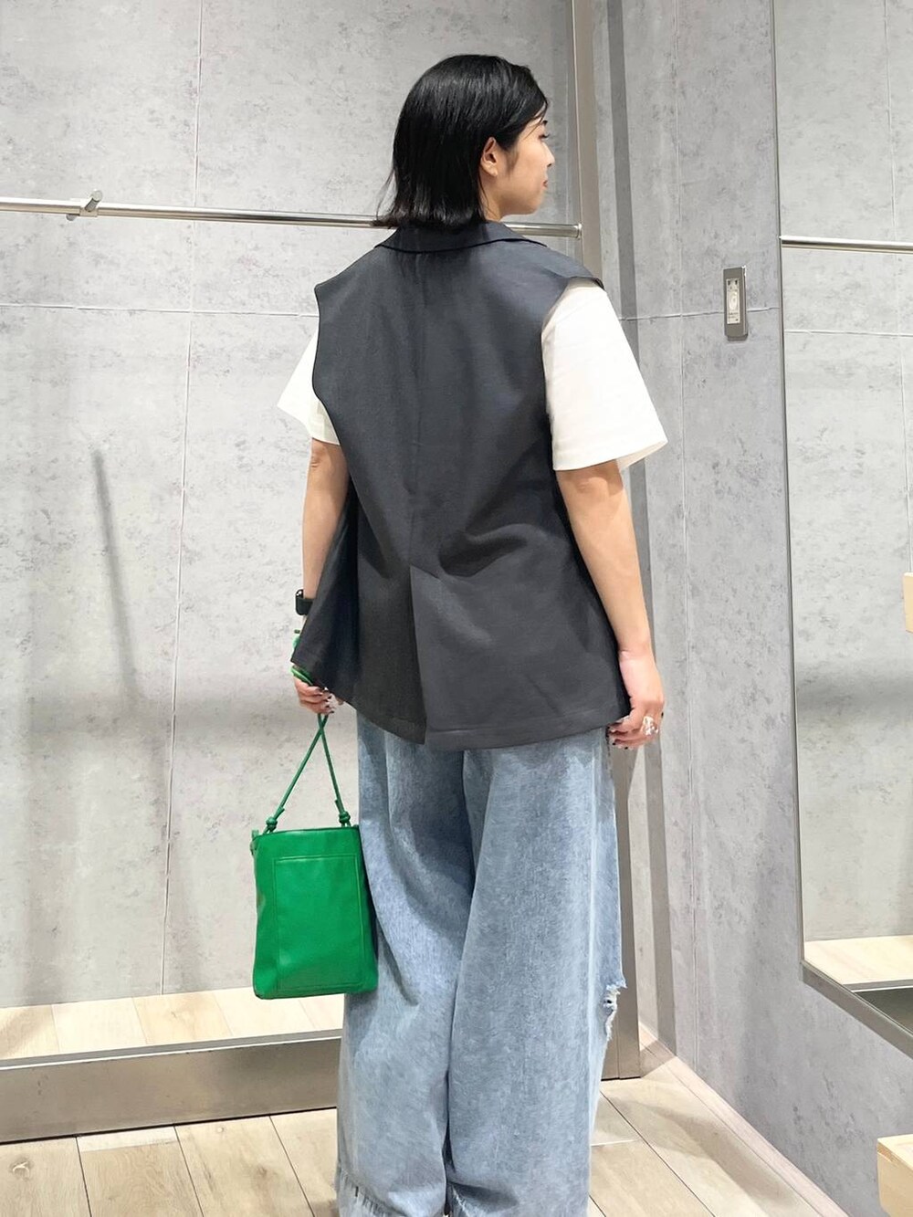 ベージュ系のサンダル、ブルー系のデニムパンツ、グリーン系のショルダーバッグを着用したレディースの夏コーディネートの3枚目の写真