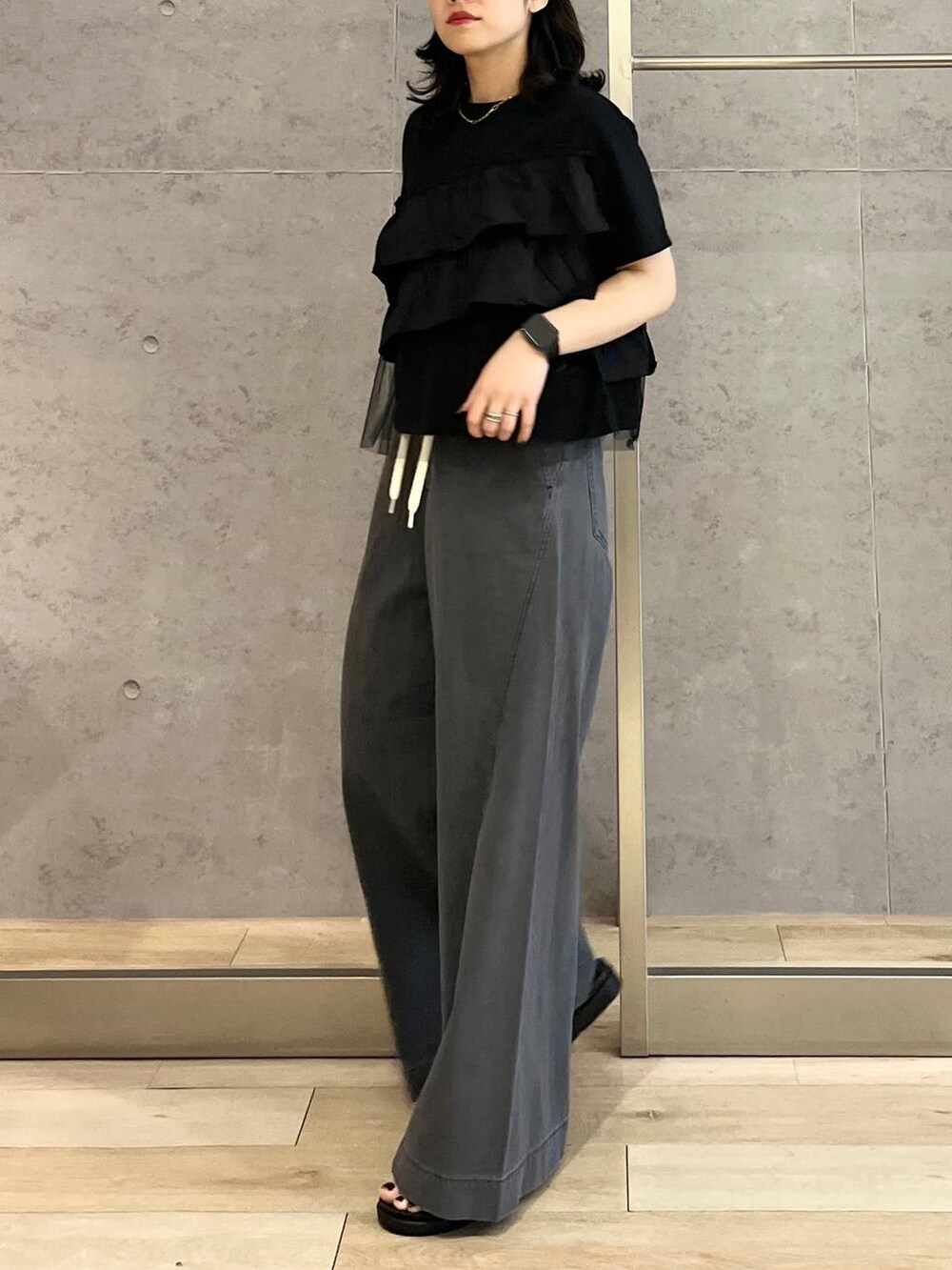 シルバー系のサンダル、ブラック系のデニムパンツ、ホワイト系のショルダーバッグを着用したレディースの春コーディネートの5枚目の写真