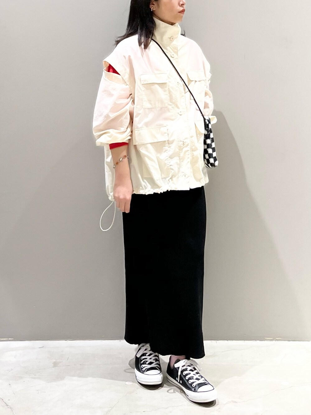 ブラック系のスカート、ブラック系のスニーカー、その他のバッグを着用したレディースの秋コーディネートの3枚目の写真