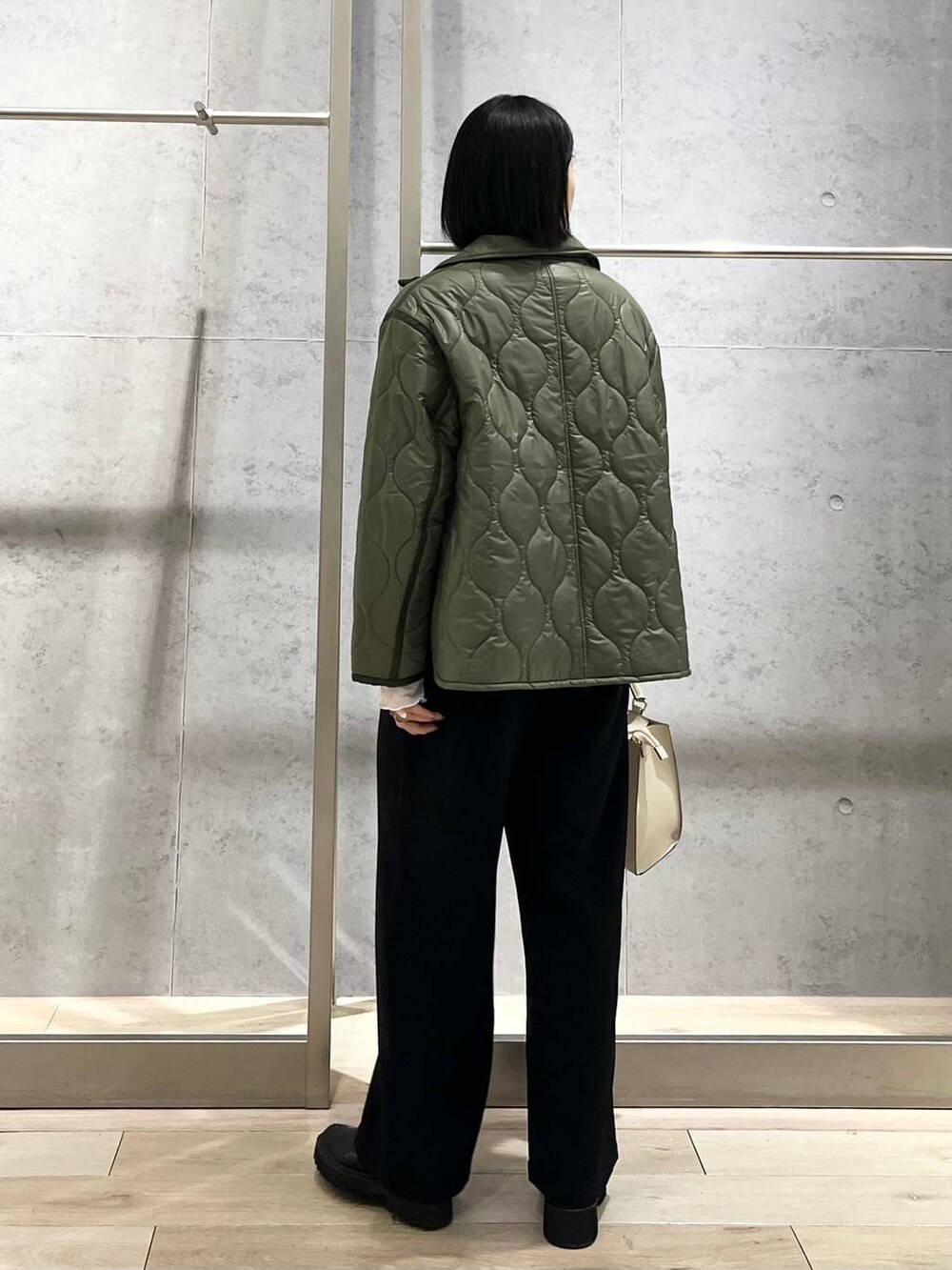 ホワイト系のTシャツ/カットソー、グリーン系のその他アウター、ブラック系のブーツを着用したレディースの冬コーディネートの4枚目の写真