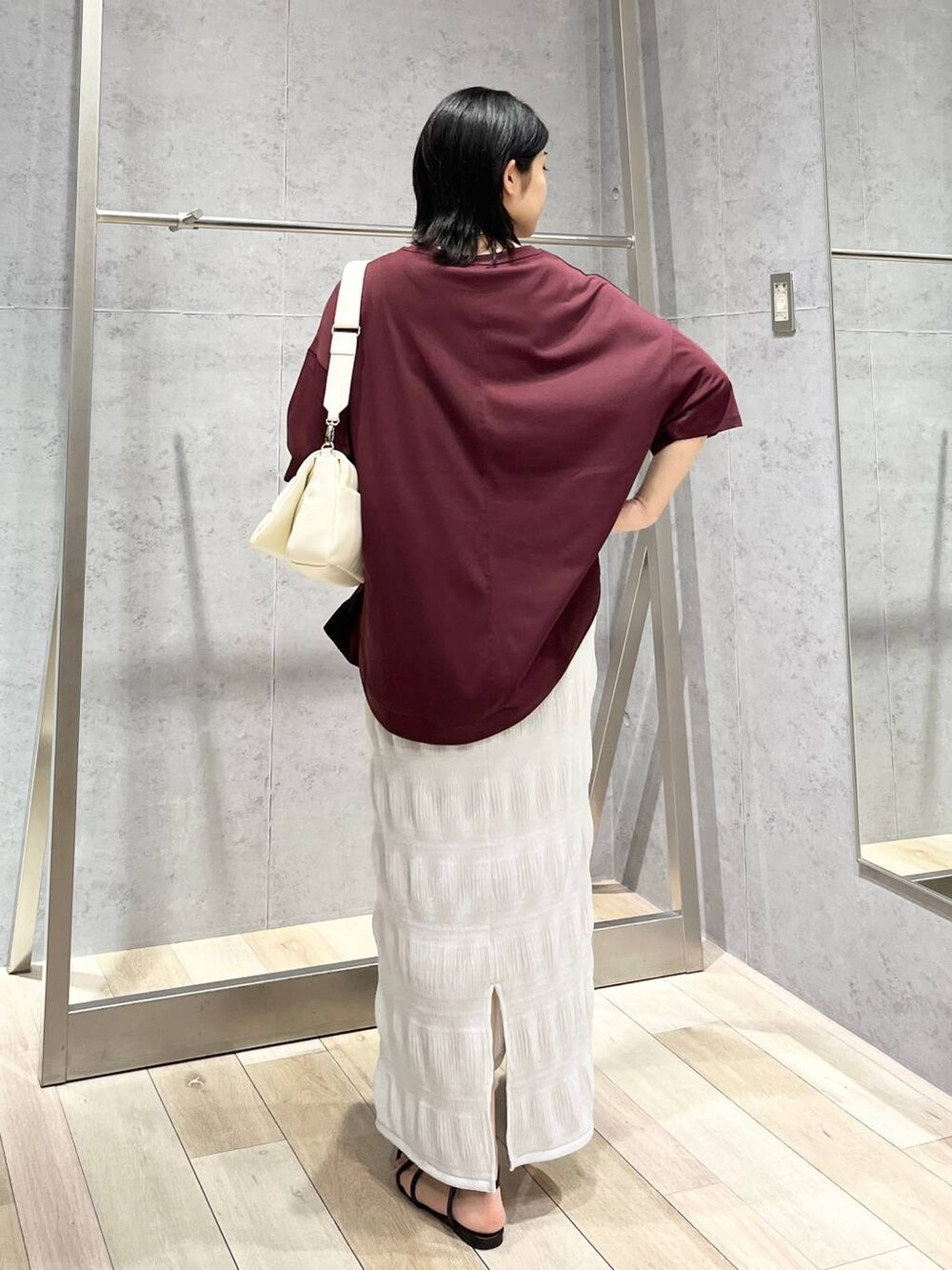 ホワイト系のショルダーバッグ、ブラック系のサンダル、レッド系のTシャツ/カットソーを着用したレディースの夏コーディネートの5枚目の写真