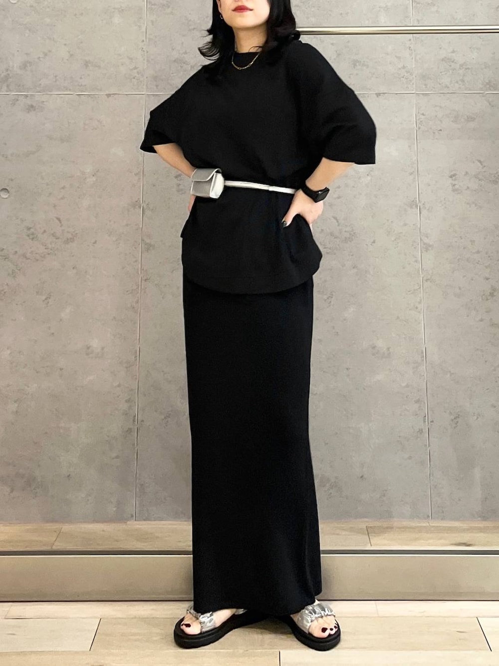 ブラック系のスカート、ブラック系のTシャツ/カットソー、シルバー系のサンダルを着用したレディースの春コーディネートの2枚目の写真