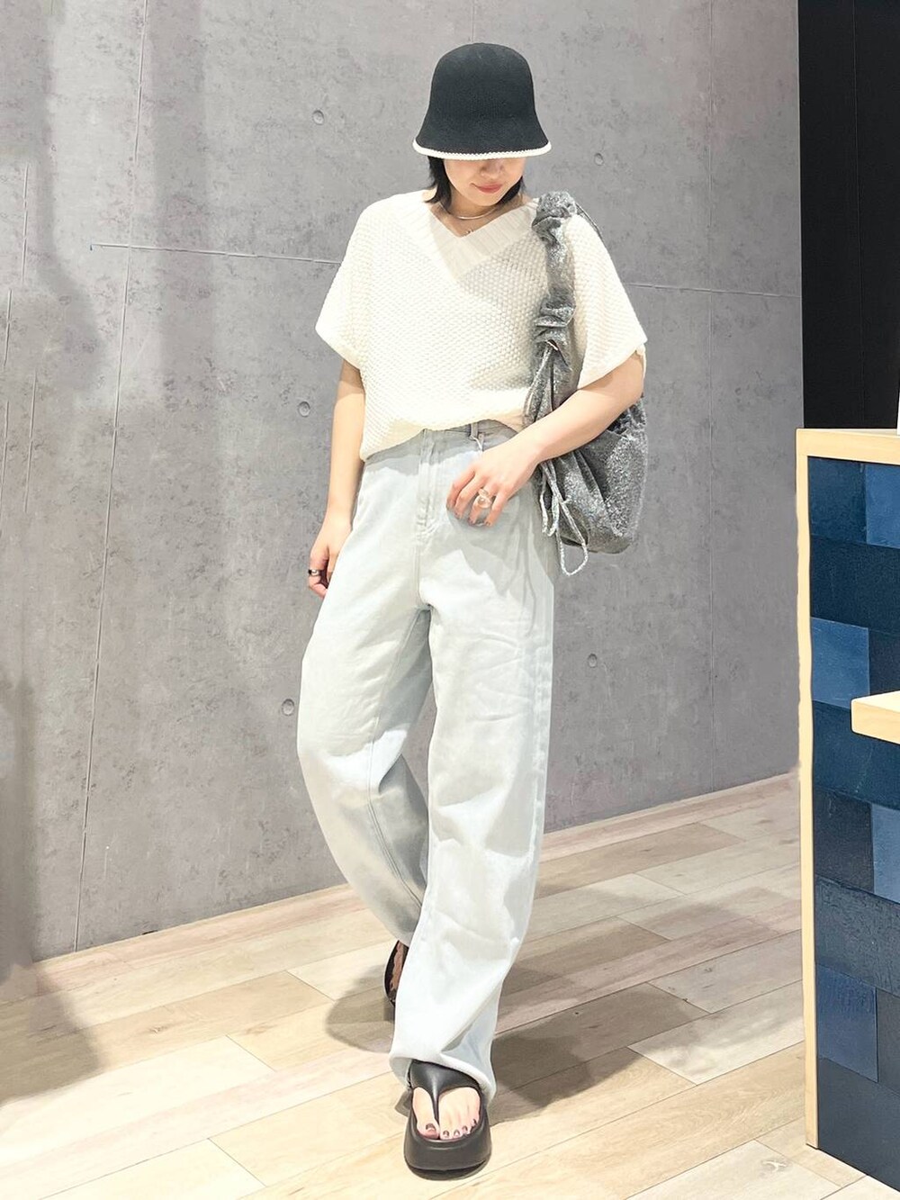 ブラック系のサンダル、ブルー系のデニムパンツ、ホワイト系のニット/セーターを着用したレディースの夏コーディネートの5枚目の写真