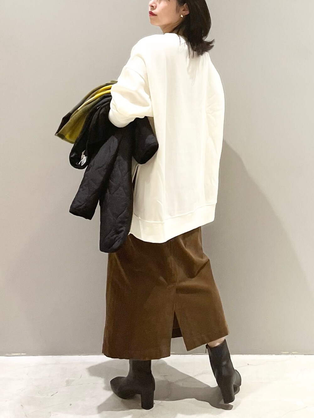 ブラウン系のスカート、ブラック系のブーツ、ブラック系のジャケット/アウターを着用したレディースの秋コーディネートの4枚目の写真