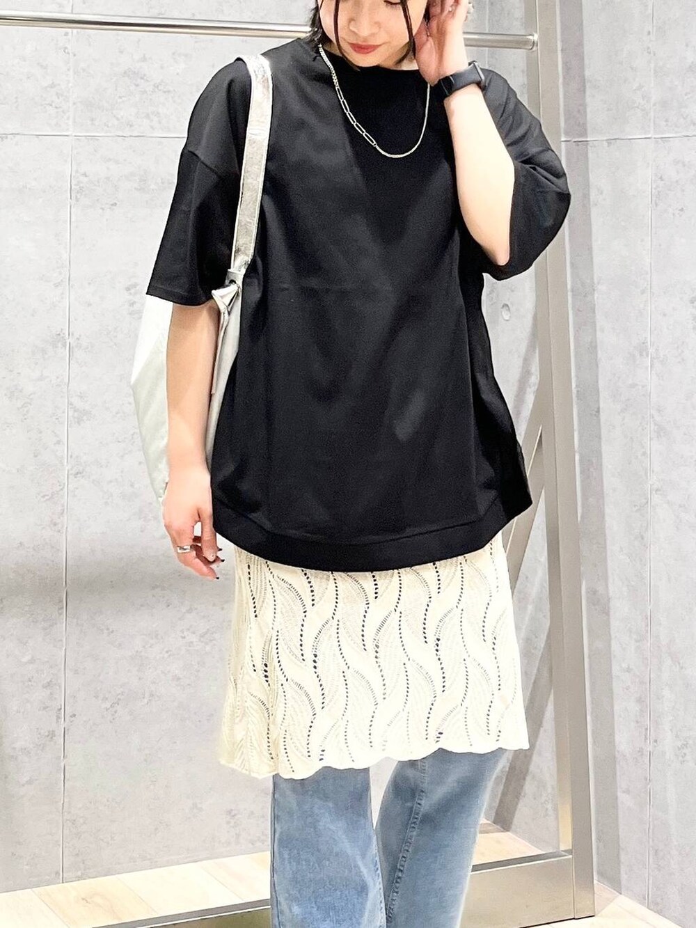 イエロー系のサンダル、グレー系のショルダーバッグ、ブルー系のデニムパンツを着用したレディースの春コーディネートの2枚目の写真