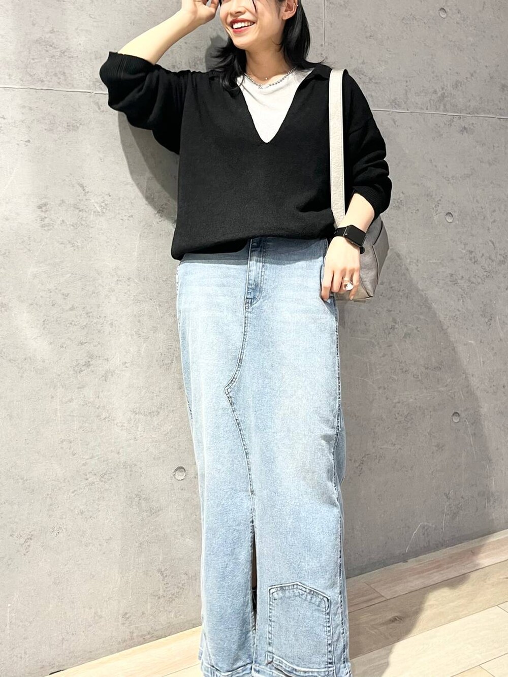 グレー系のTシャツ/カットソー、ブルー系のデニムスカート、ブラック系のニット/セーターを着用したレディースの冬コーディネートの5枚目の写真