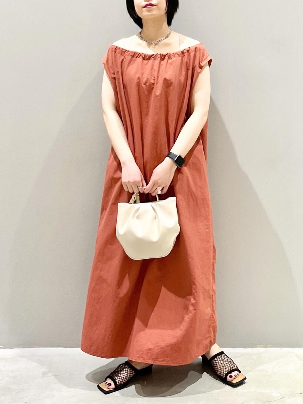 ブラウン系のワンピース、ホワイト系のバッグ、ブラック系のサンダルを着用したレディースの夏コーディネートの3枚目の写真