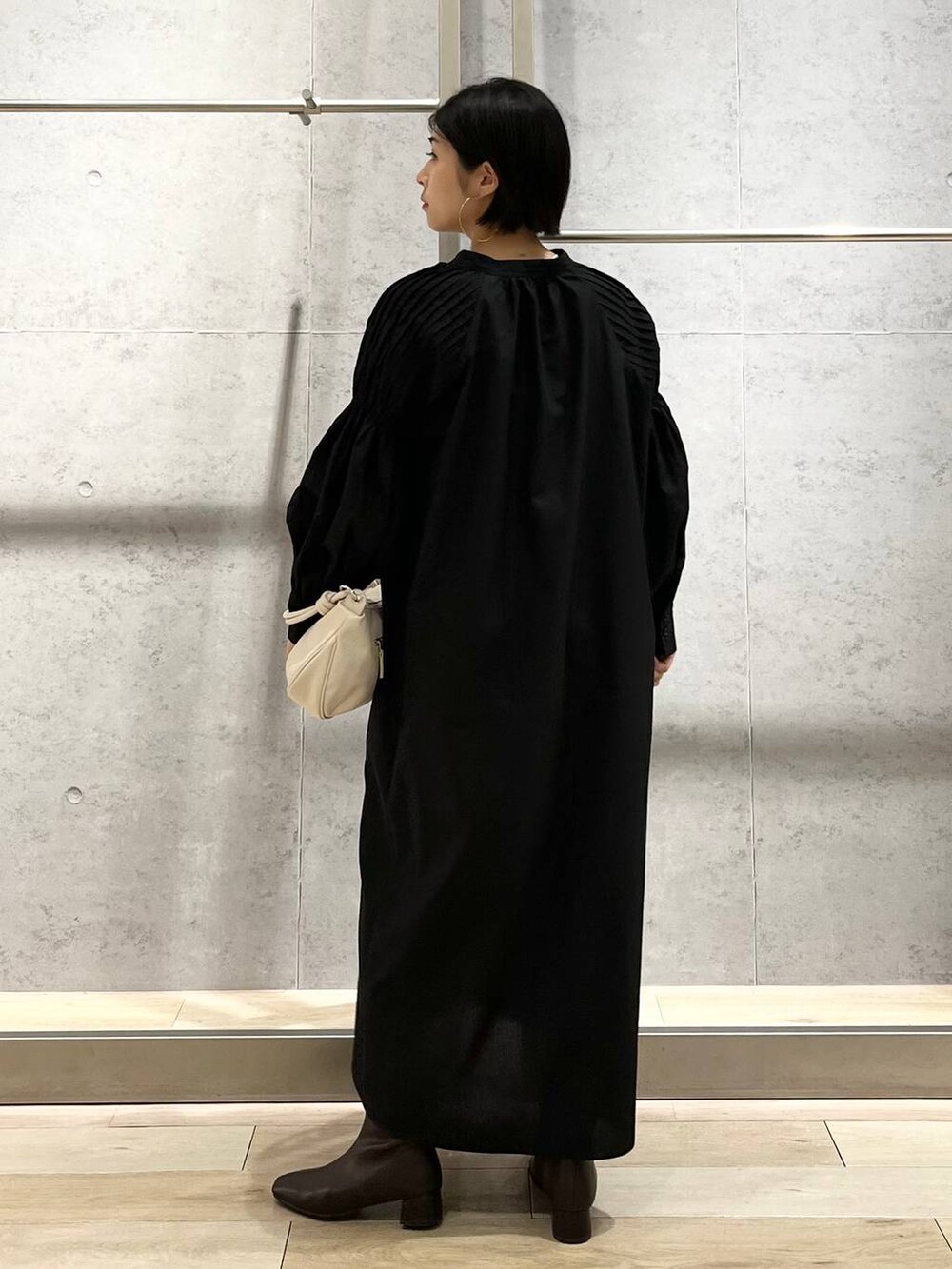 ホワイト系のキャミソール、ブラック系のワンピース、ホワイト系のショルダーバッグを着用したレディースの秋コーディネートの8枚目の写真