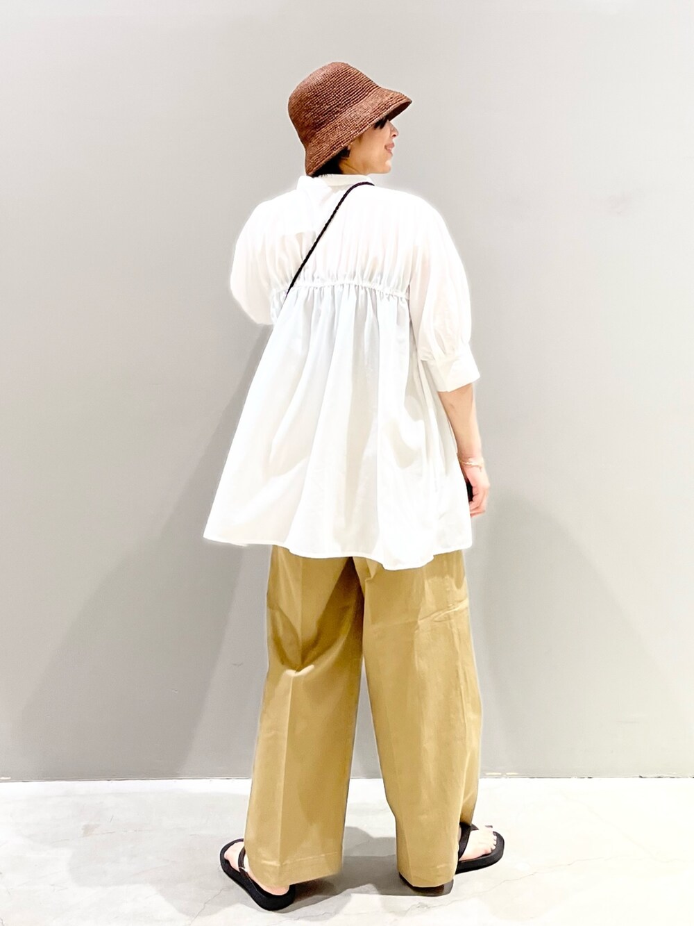 ブラック系のサンダル、ベージュ系のチノパンツ、ブラック系のショルダーバッグを着用したレディースの夏コーディネートの5枚目の写真