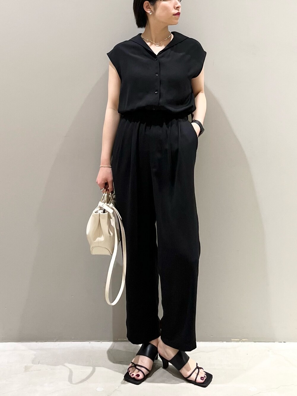 ブラック系のつなぎ/オールインワン、ホワイト系のバッグ、ブラック系のサンダルを着用したレディースの春コーディネートの6枚目の写真