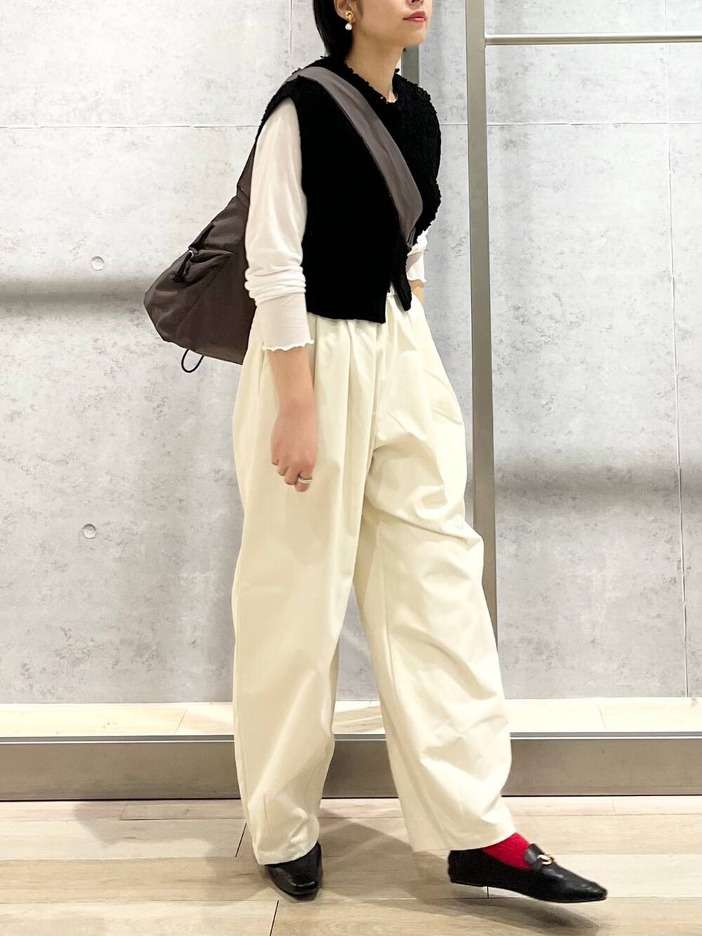 ブラック系のローファー、ホワイト系のTシャツ/カットソー、ブラック系のベストを着用したレディースの秋コーディネートの5枚目の写真