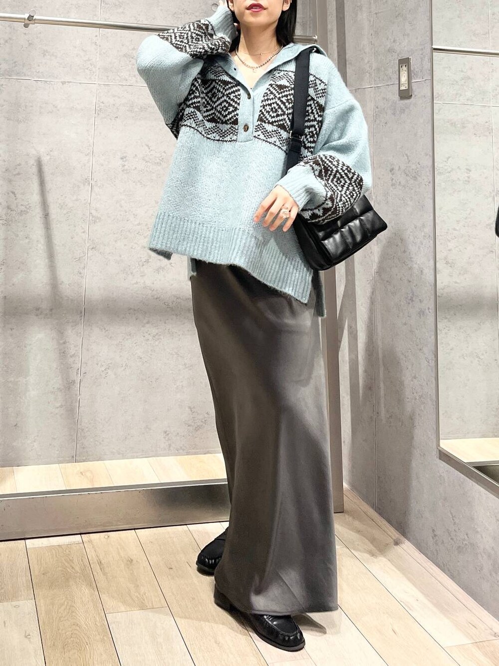 ブラック系のショルダーバッグ、グレー系のスカート、ブラック系のローファーを着用したレディースの秋コーディネートの5枚目の写真