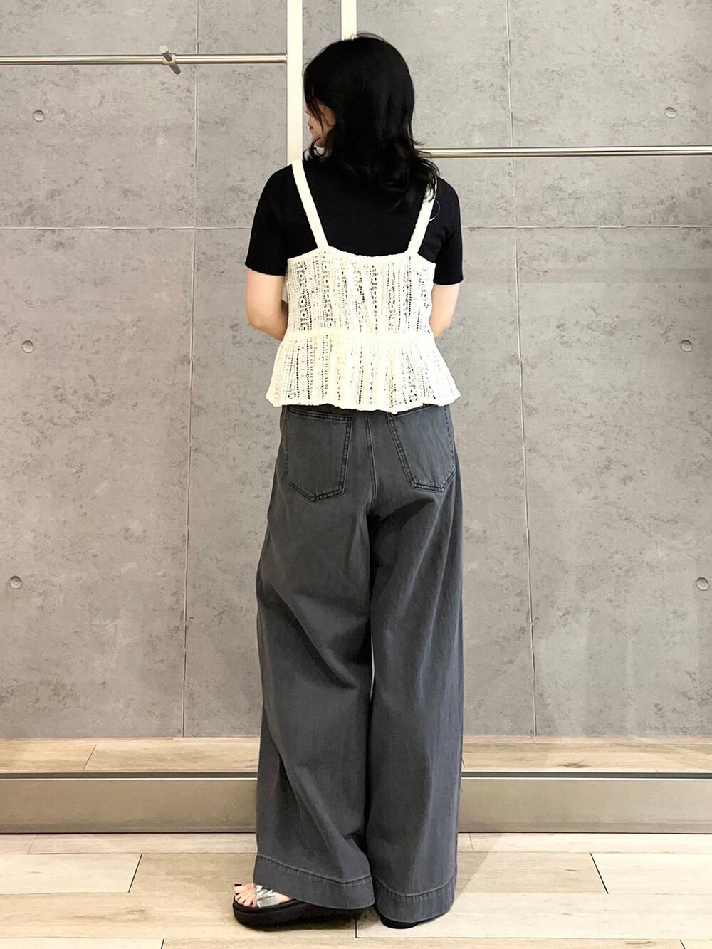 ブラック系のTシャツ/カットソー、シルバー系のサンダル、ブラック系のデニムパンツを着用したレディースの春コーディネートの4枚目の写真