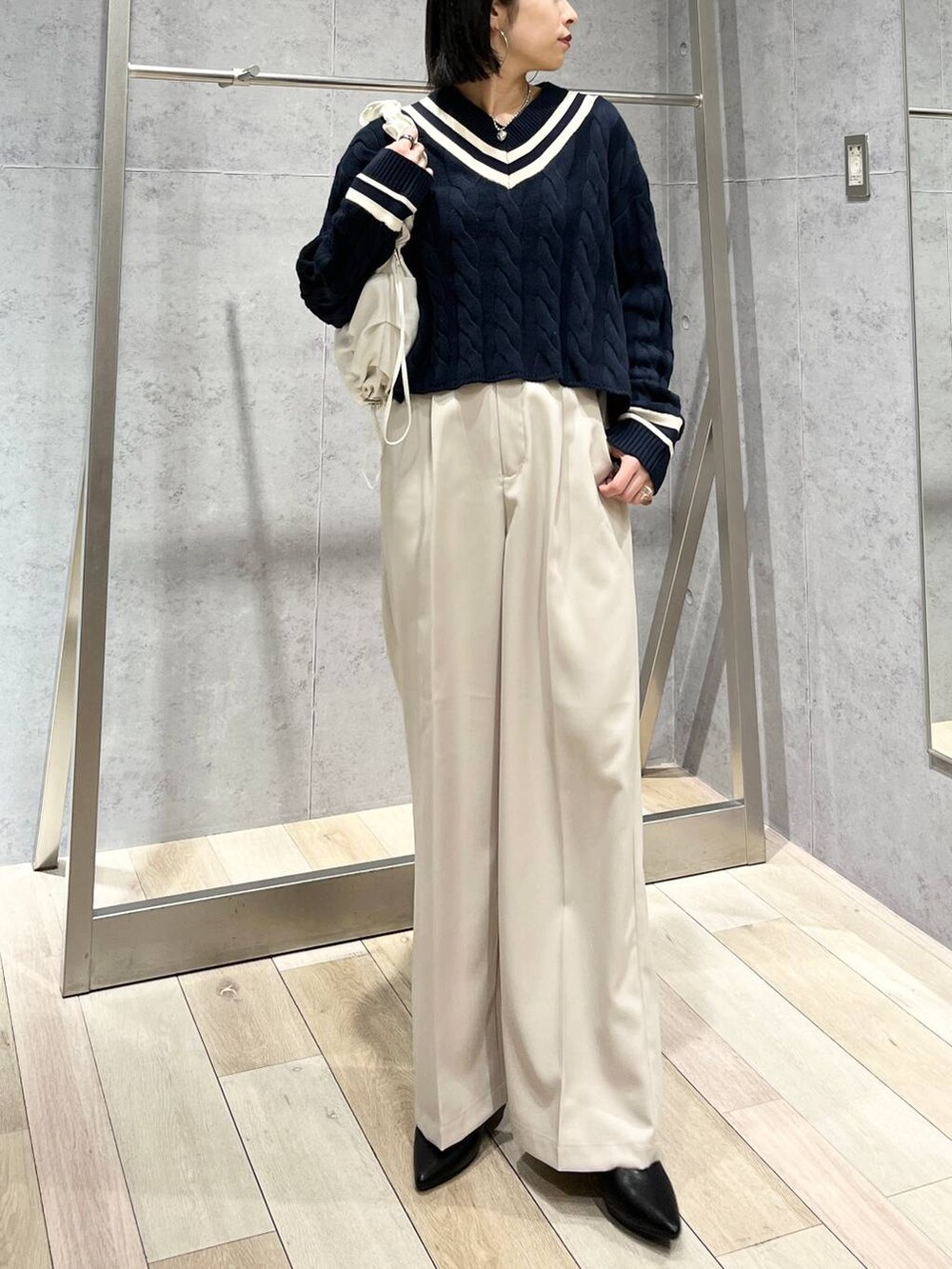 ブルー系のニット/セーター、ホワイト系のショルダーバッグ、ブラック系のパンプスを着用したレディースの冬コーディネートの9枚目の写真