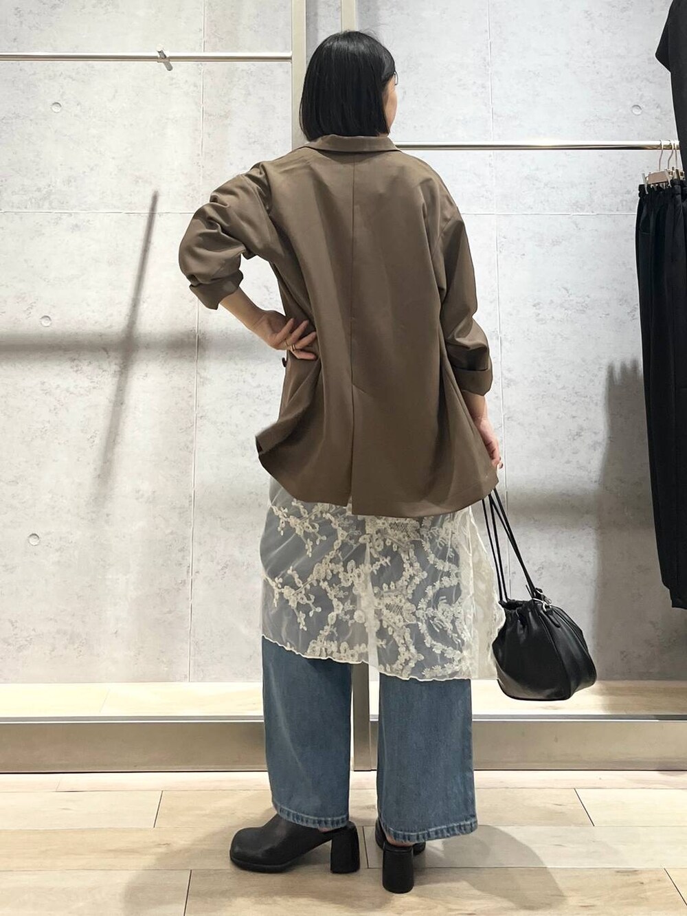 ブルー系のデニムパンツ、ブラック系のその他シューズ、ブラック系のショルダーバッグを着用したレディースの秋コーディネートの4枚目の写真