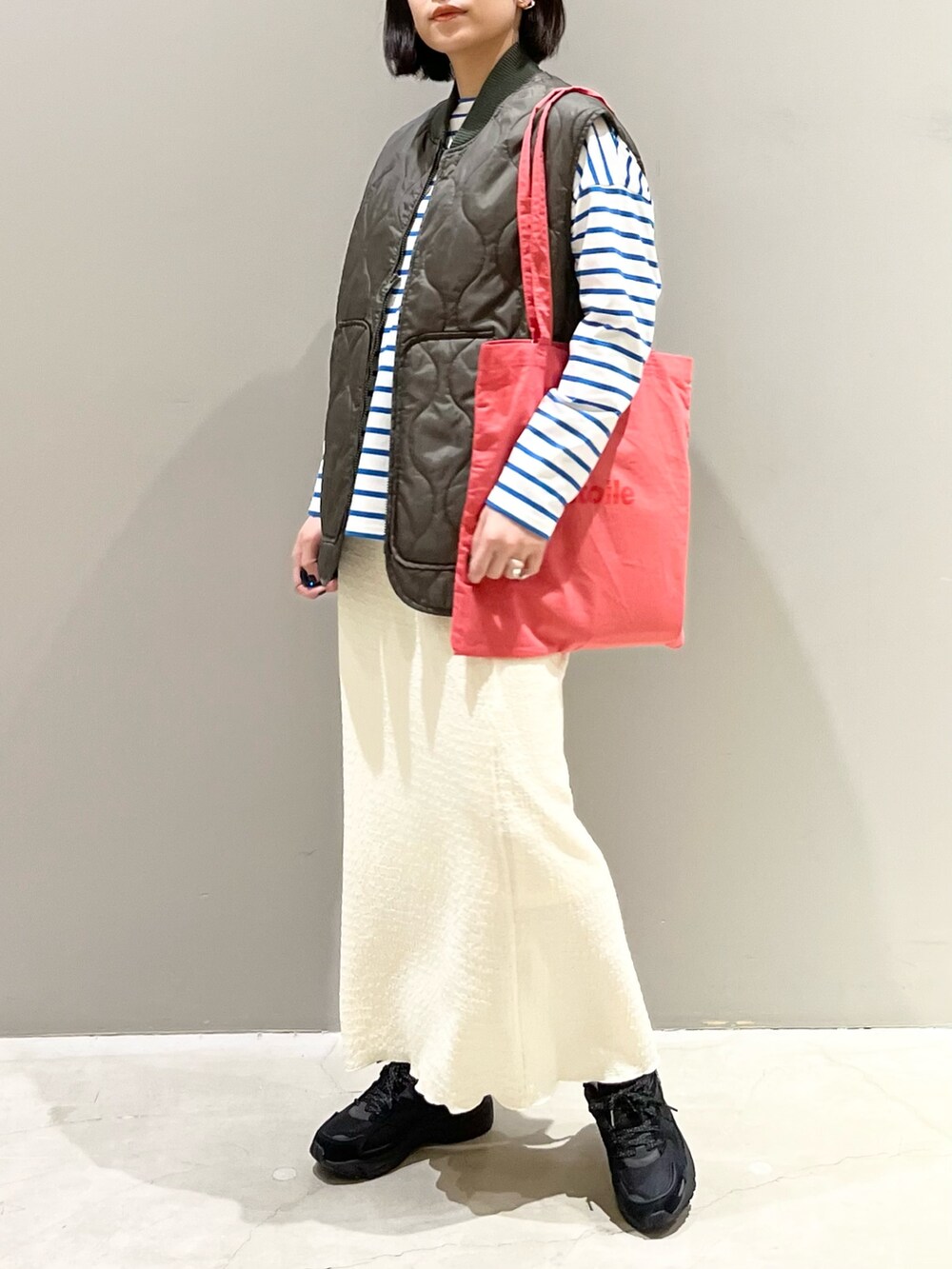 ピンク系のトートバッグ、ブラック系のスニーカー、ブルー系のTシャツ/カットソーを着用したレディースの春コーディネートの4枚目の写真