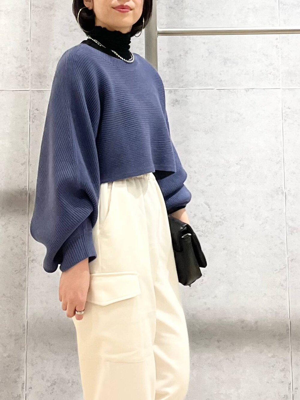 ブルー系のワンピース、ブラック系のTシャツ/カットソー、ブラック系のショルダーバッグを着用したレディースの秋コーディネートの8枚目の写真