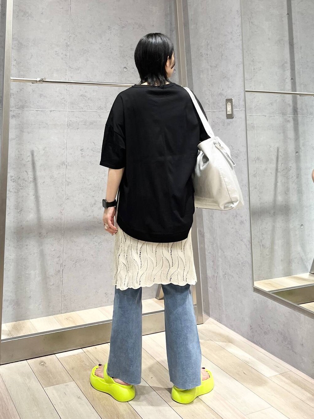 イエロー系のサンダル、グレー系のショルダーバッグ、ブルー系のデニムパンツを着用したレディースの春コーディネートの4枚目の写真