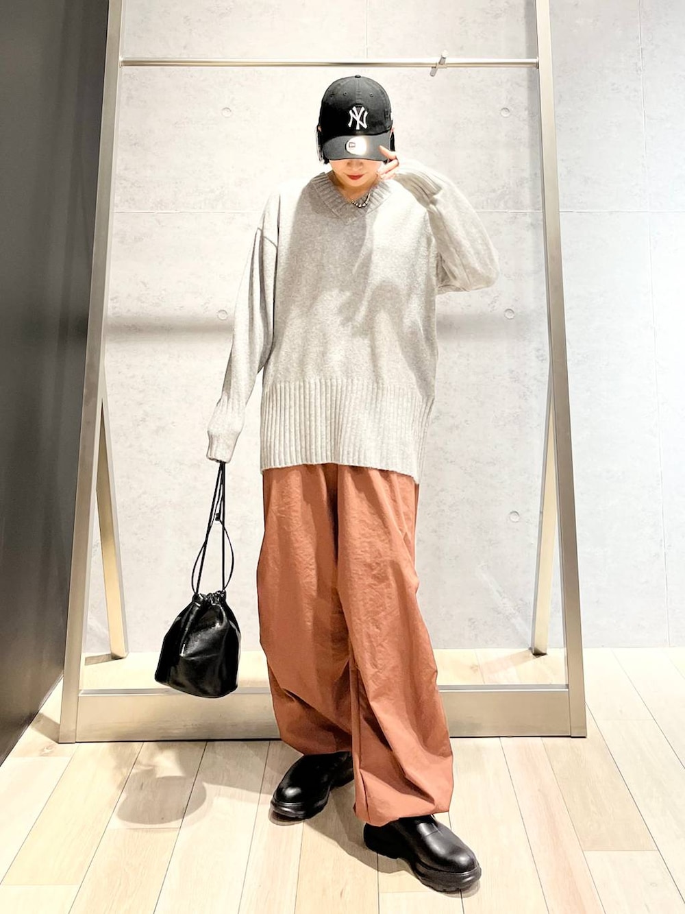 グレー系のその他パンツ、ブラック系のブーツ、グレー系のニット/セーターを着用したレディースの秋コーディネートの2枚目の写真