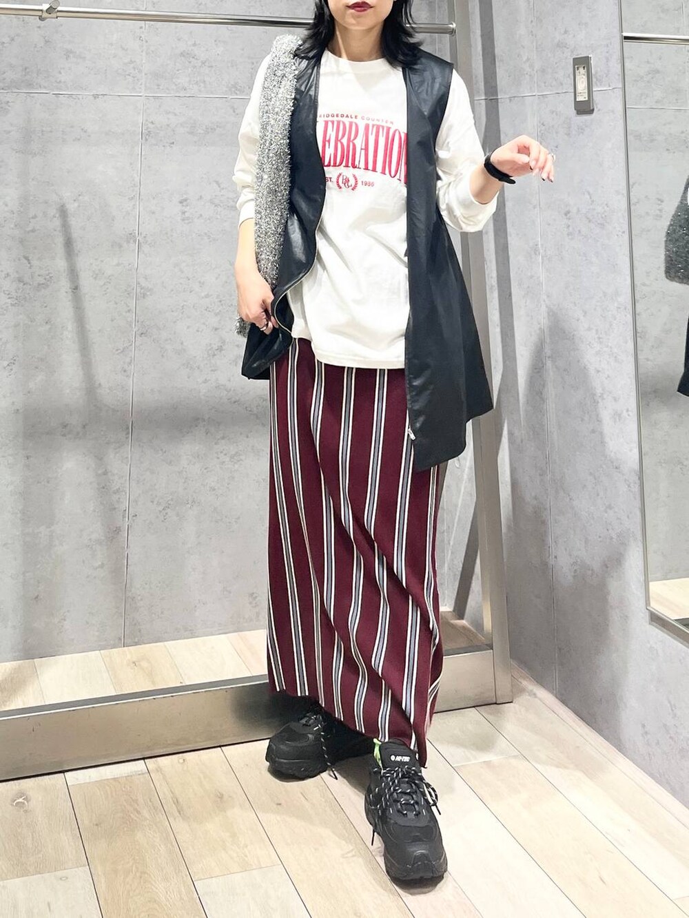 シルバー系のショルダーバッグ、レッド系のスカート、ブラック系のワンピースを着用したレディースの秋コーディネートの5枚目の写真