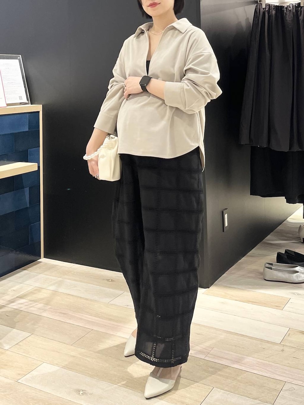 ホワイト系のパンプス、ホワイト系のショルダーバッグ、ベージュ系のシャツ/ブラウスを着用したレディースの冬コーディネートの5枚目の写真