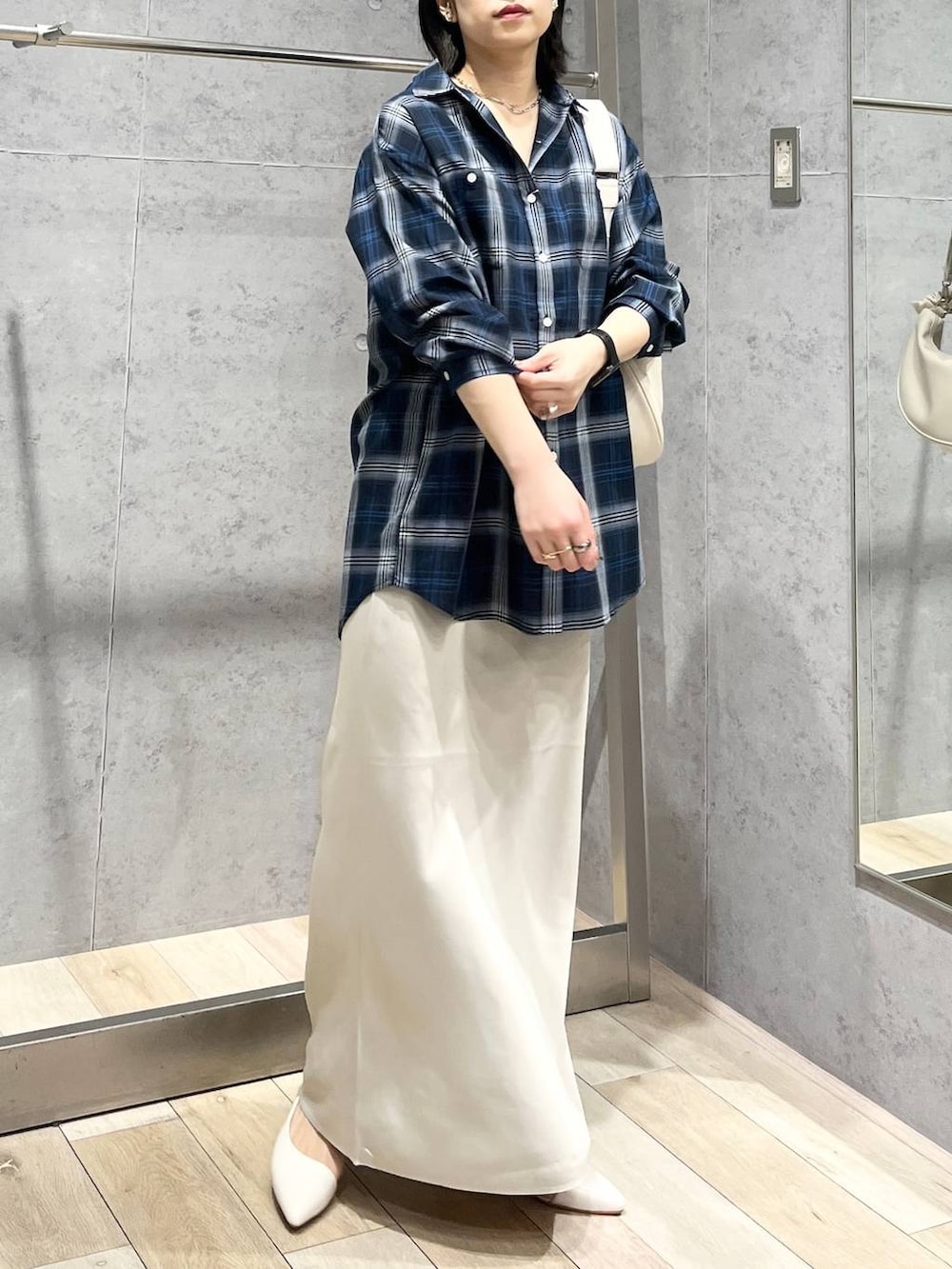 ホワイト系のショルダーバッグ、ホワイト系のスカート、ブルー系のシャツ/ブラウスを着用したレディースの冬コーディネートの5枚目の写真