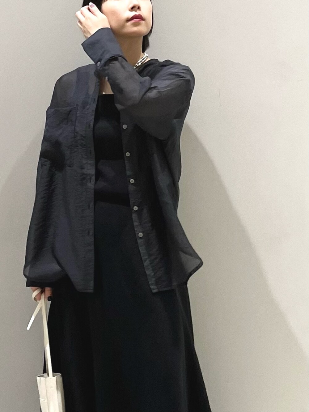 ホワイト系のサンダル、オレンジ系のバッグ、ブラック系のスカートを着用したレディースの夏コーディネートの2枚目の写真