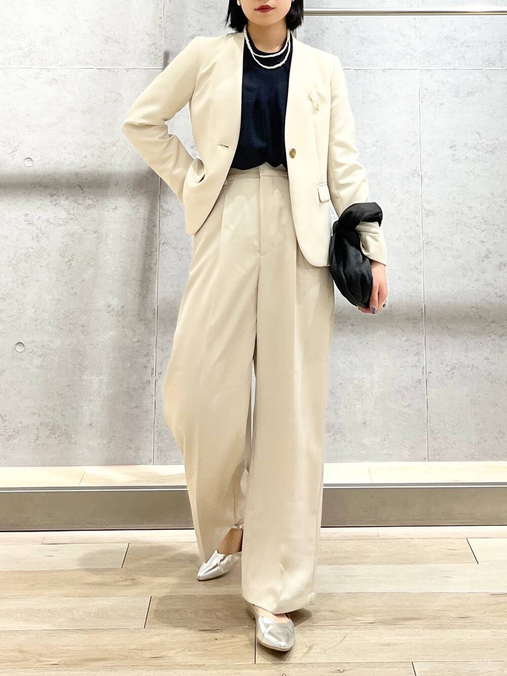 ブラック系のハンドバッグ、ブルー系のシャツ/ブラウス、ホワイト系のノーカラージャケットを着用したレディースの冬コーディネートの6枚目の写真