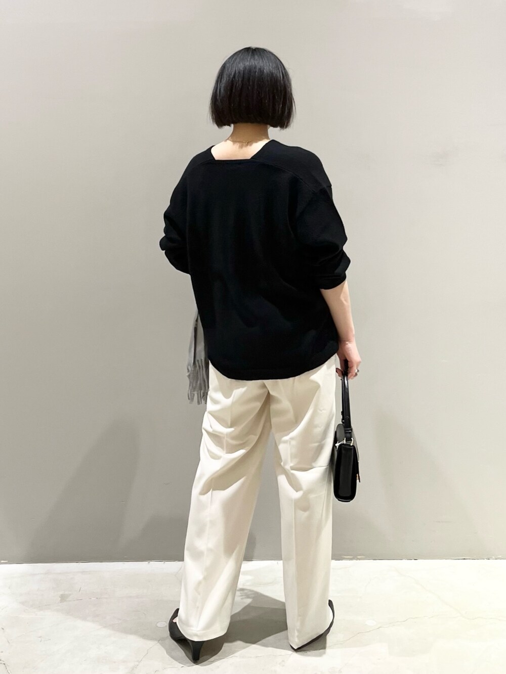 ブラック系のニット/セーター、ブラック系のハンドバッグ、ブラック系のパンツを着用したレディースの冬コーディネートの3枚目の写真