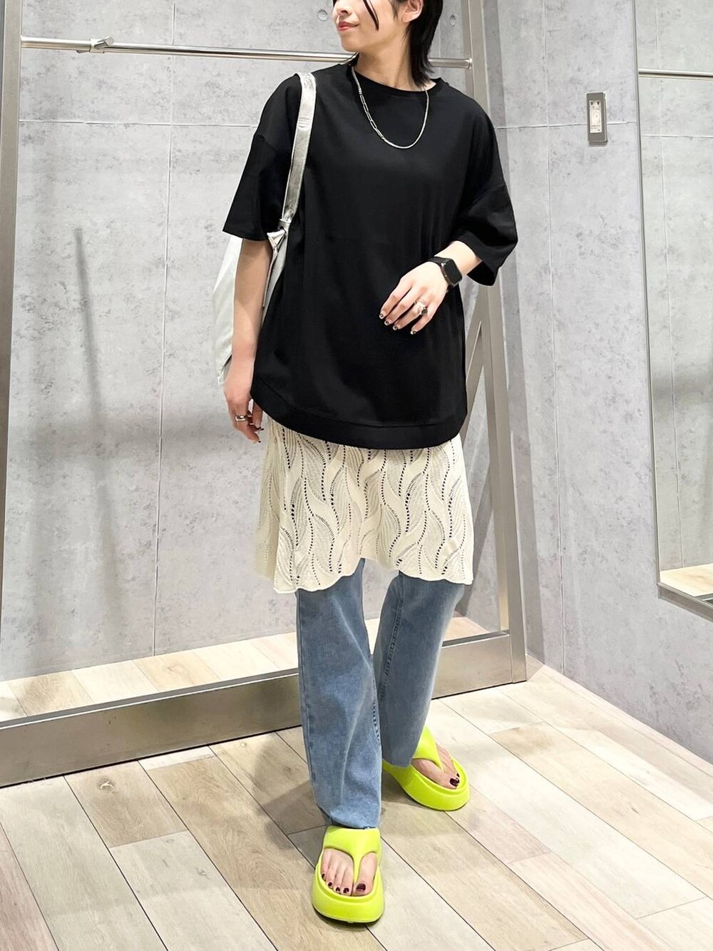 イエロー系のサンダル、グレー系のショルダーバッグ、ブルー系のデニムパンツを着用したレディースの春コーディネートの6枚目の写真