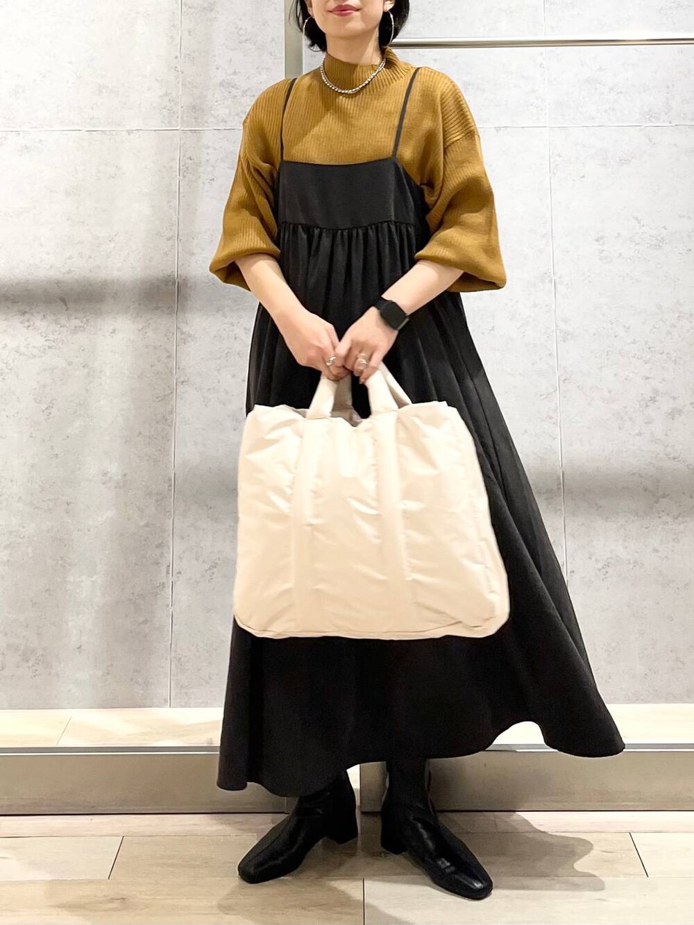 ブラウン系のニット/セーター、ホワイト系のショルダーバッグ、ブラック系のブーツを着用したレディースの秋コーディネートの2枚目の写真