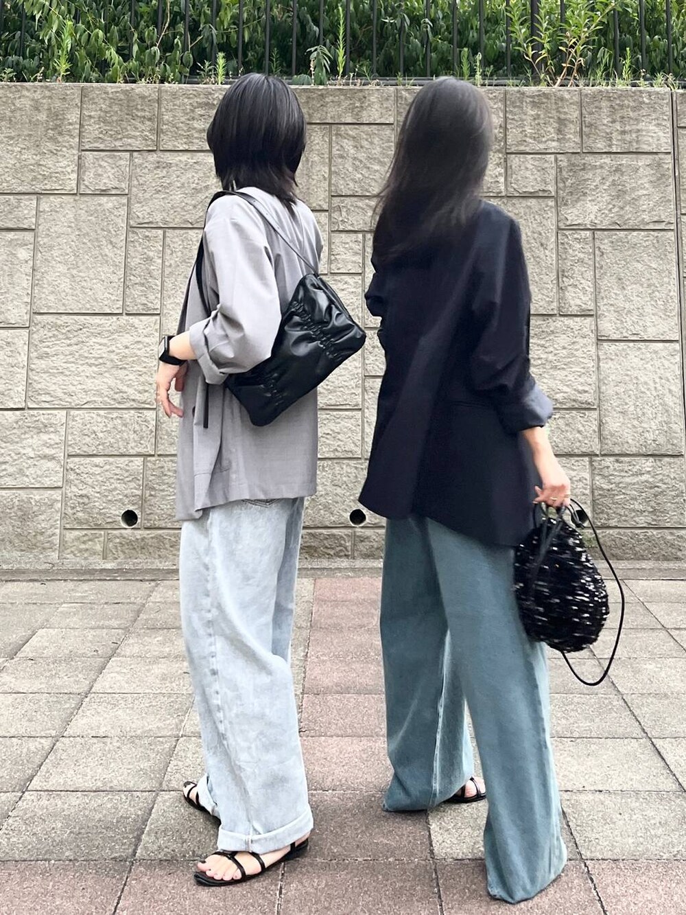 ブラック系のサンダル、ブラック系のショルダーバッグ、ブルー系のデニムパンツを着用したレディースの秋コーディネートの3枚目の写真
