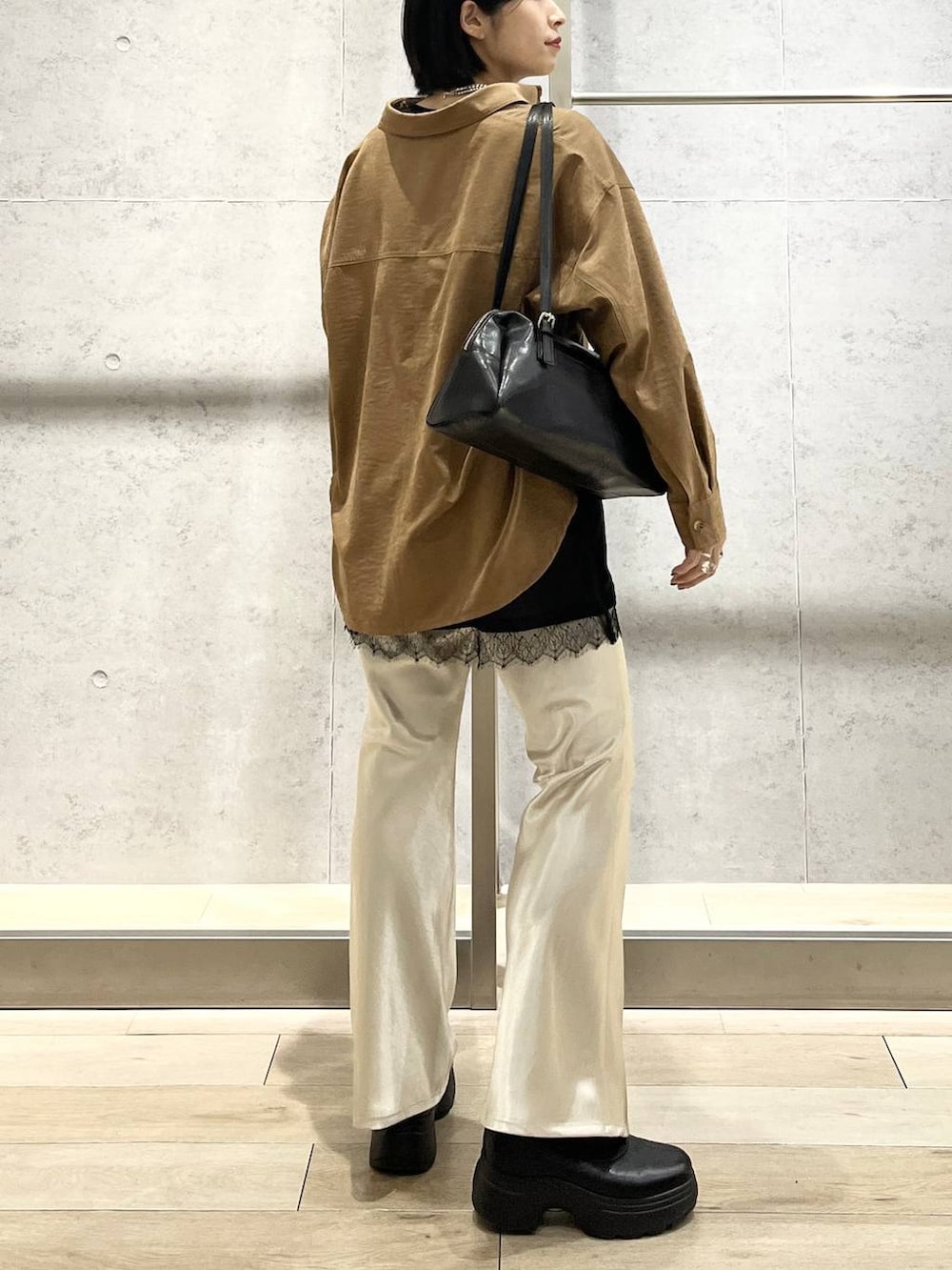 ブラック系のボストンバッグ、ブラック系のブーツ、イエロー系のシャツ/ブラウスを着用したレディースの冬コーディネートの3枚目の写真