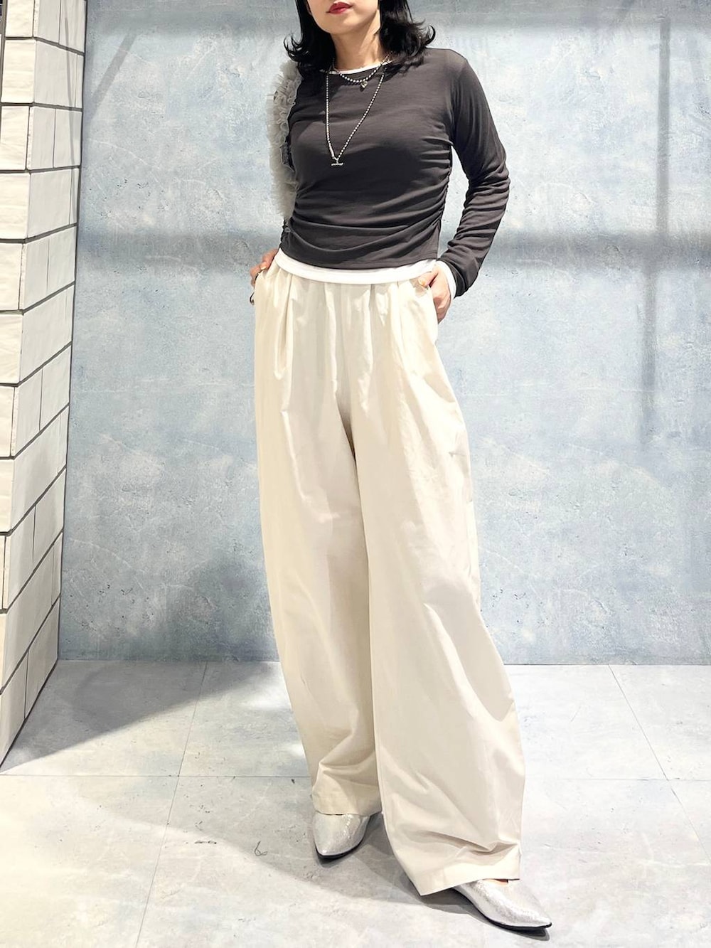 グレー系のショルダーバッグ、グレー系のTシャツ/カットソー、シルバー系のパンプスを着用したレディースの春コーディネートの4枚目の写真