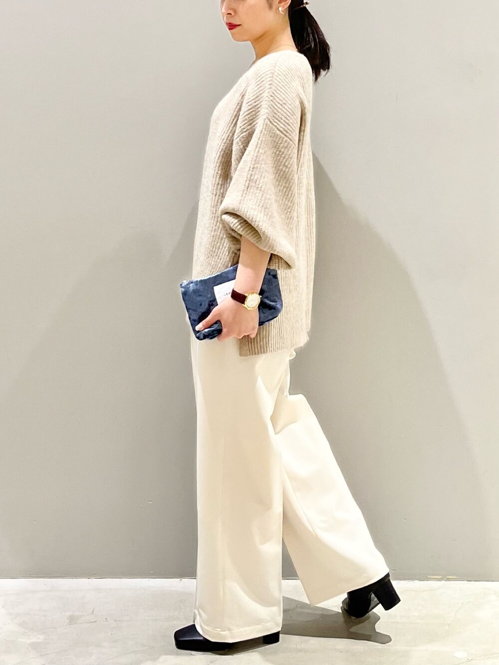 ベージュ系のニット/セーター、ホワイト系のスラックス、ブラック系のブーツを着用したレディースの秋コーディネートの4枚目の写真